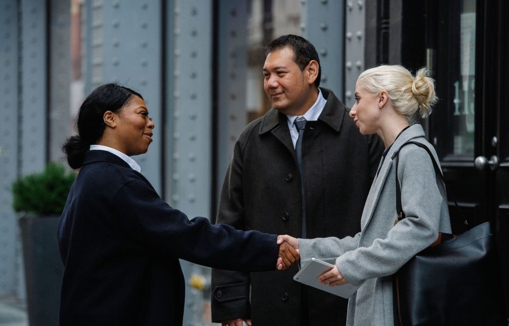 Business professionals shaking hands outside an office