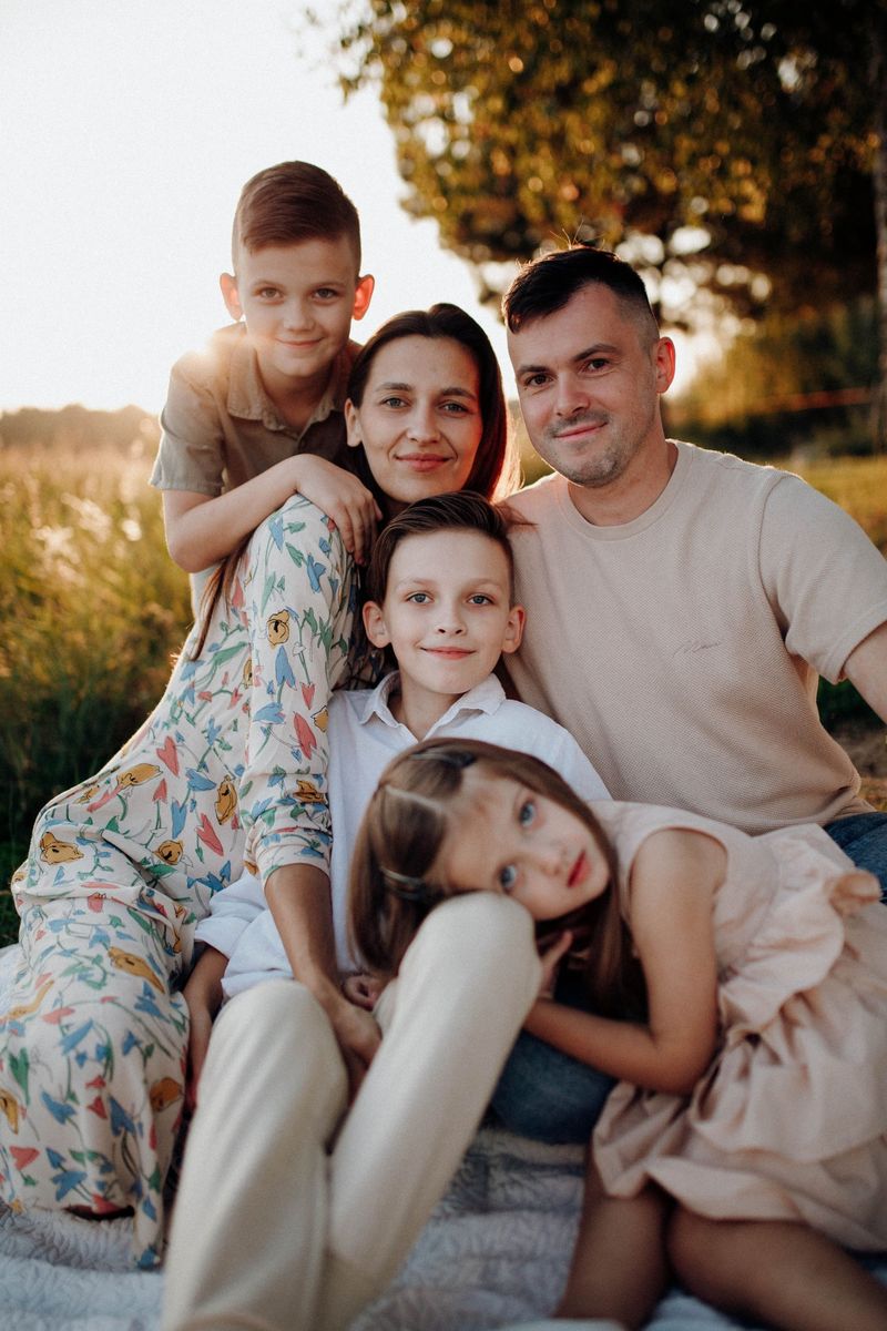 Family of five together outdoors at sunset