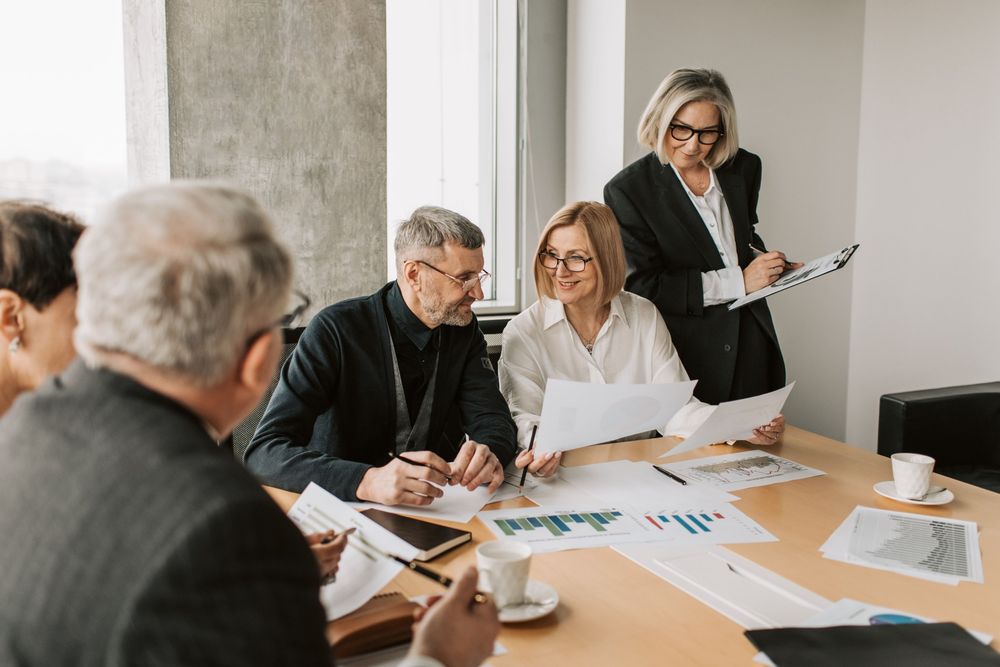 Investment team reviewing financial charts around a boardroom table